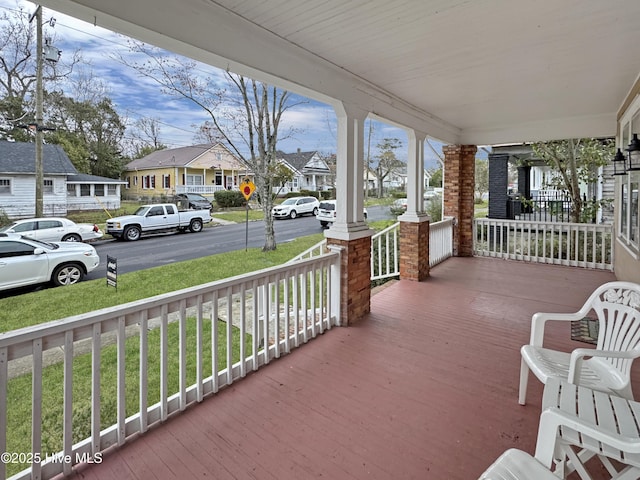 deck with a residential view and covered porch