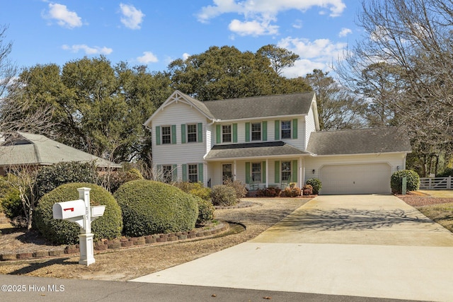 view of front facade featuring a garage, driveway, and fence