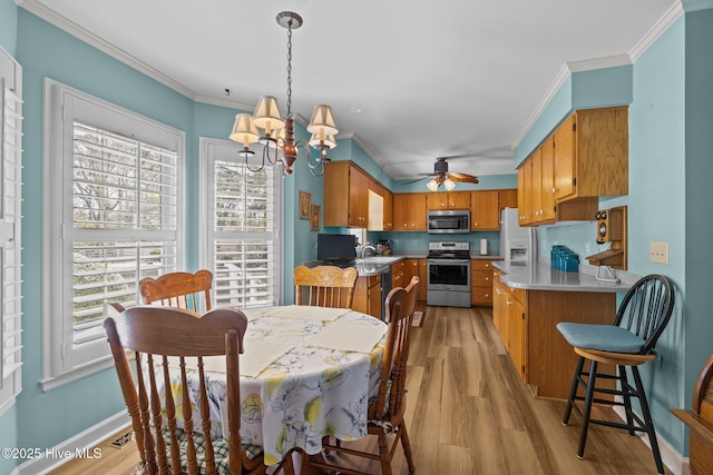 dining room featuring ornamental molding, baseboards, light wood finished floors, and ceiling fan with notable chandelier