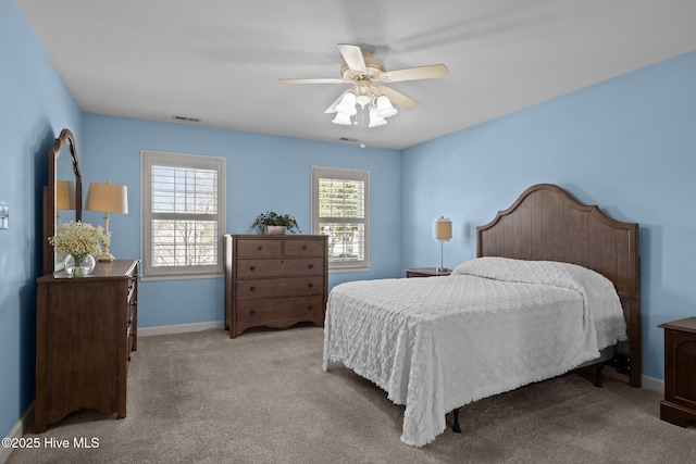 carpeted bedroom featuring baseboards, visible vents, and a ceiling fan