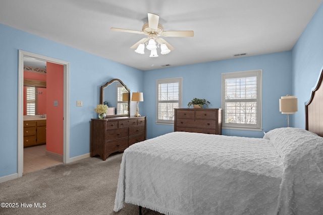 carpeted bedroom featuring a ceiling fan, visible vents, and baseboards