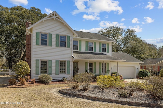 view of front of house featuring a garage, driveway, and fence