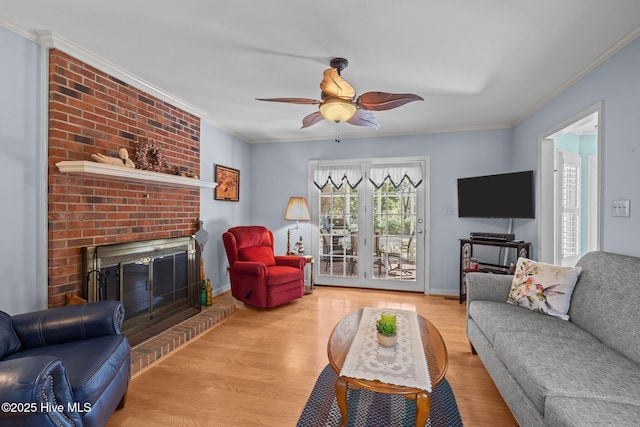 living room with ornamental molding, a fireplace, and wood finished floors