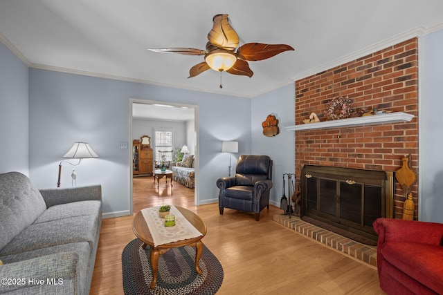 living area featuring a brick fireplace, baseboards, ornamental molding, and wood finished floors