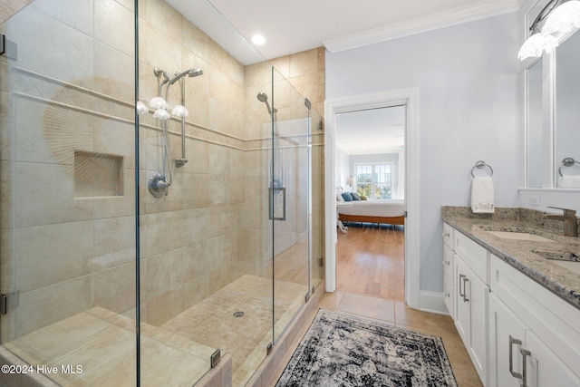 ensuite bathroom featuring ornamental molding, a stall shower, ensuite bath, and vanity