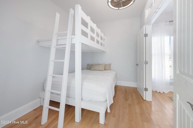 bedroom with light wood-type flooring and baseboards