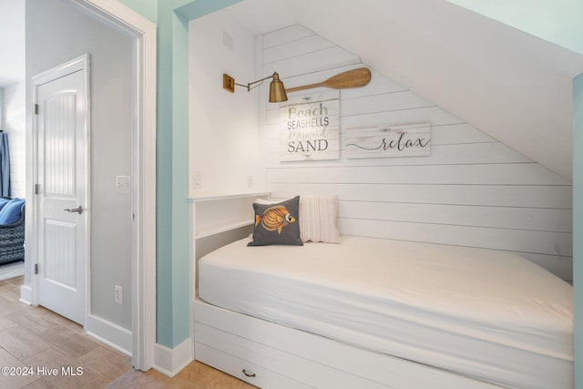 bedroom with lofted ceiling and wood finished floors