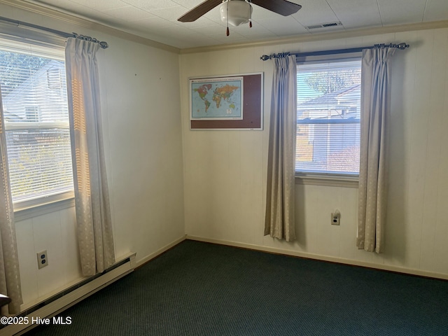 empty room featuring plenty of natural light, dark carpet, a baseboard radiator, and a ceiling fan