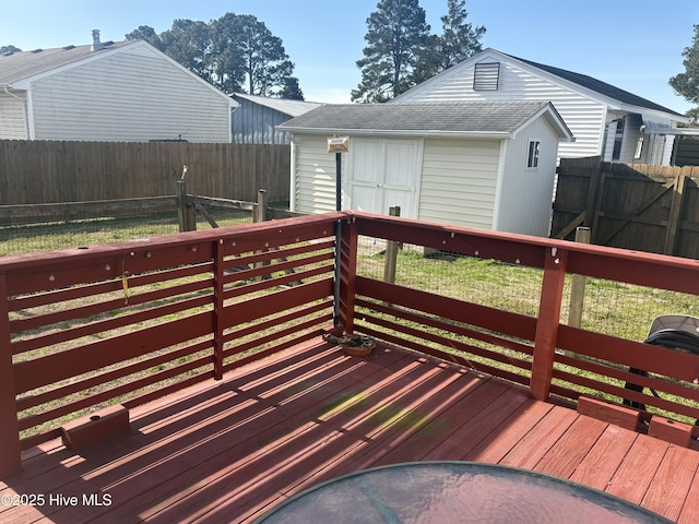 deck featuring an outbuilding, a fenced backyard, and a storage shed