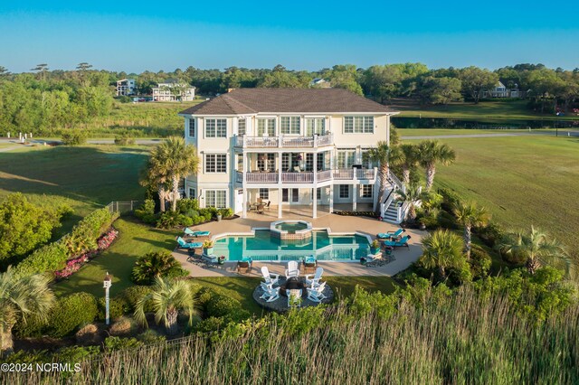 beach home featuring a balcony, a front lawn, an attached garage, and curved driveway