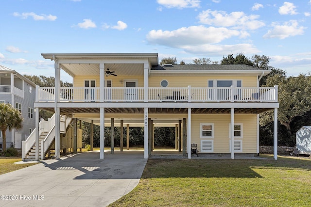 view of front facade with ceiling fan, a front lawn, stairway, a carport, and driveway