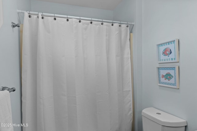 full bathroom featuring curtained shower and toilet