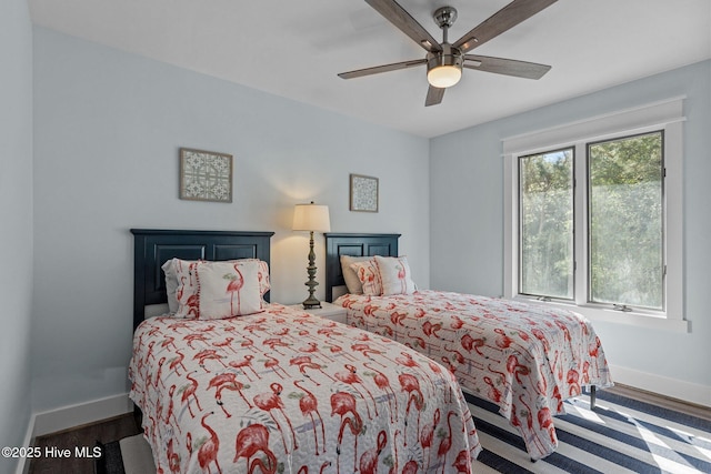 bedroom with multiple windows, ceiling fan, baseboards, and wood finished floors