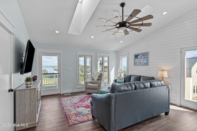 living room with high vaulted ceiling, recessed lighting, a skylight, ceiling fan, and dark wood-style flooring