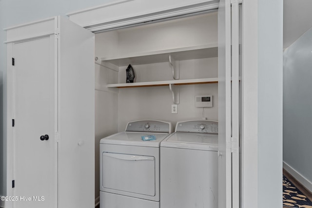 clothes washing area featuring washing machine and clothes dryer, laundry area, and baseboards