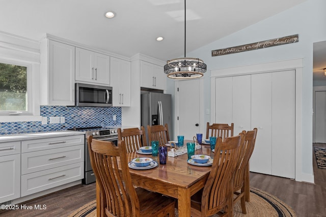 dining room featuring dark wood finished floors, lofted ceiling, recessed lighting, and a chandelier