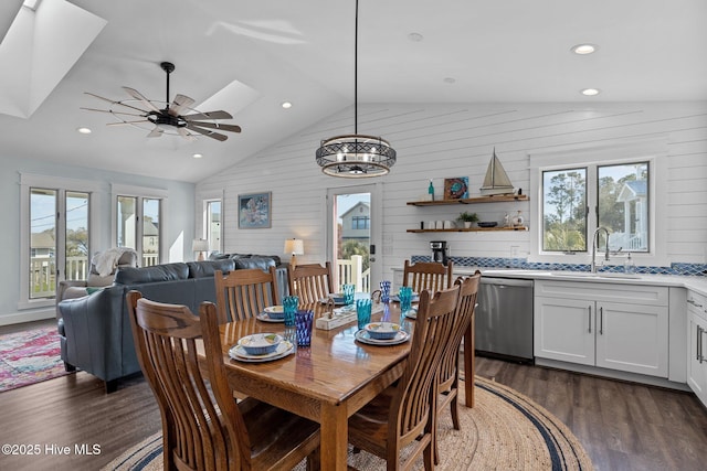 dining room featuring lofted ceiling with skylight, a healthy amount of sunlight, dark wood-type flooring, and ceiling fan