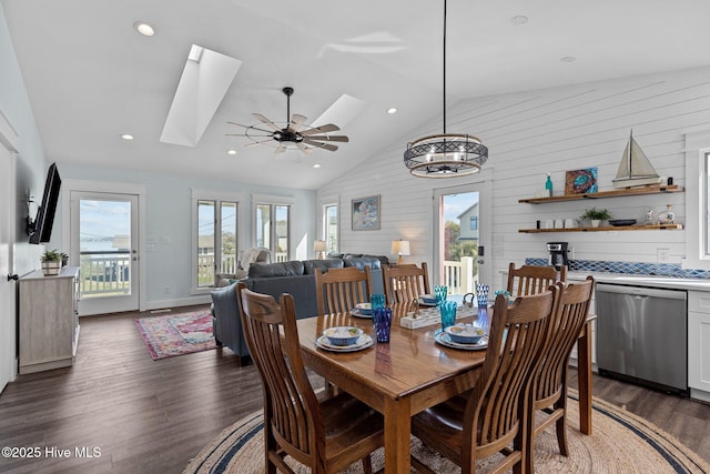 dining room with a ceiling fan, vaulted ceiling with skylight, recessed lighting, and dark wood-style floors