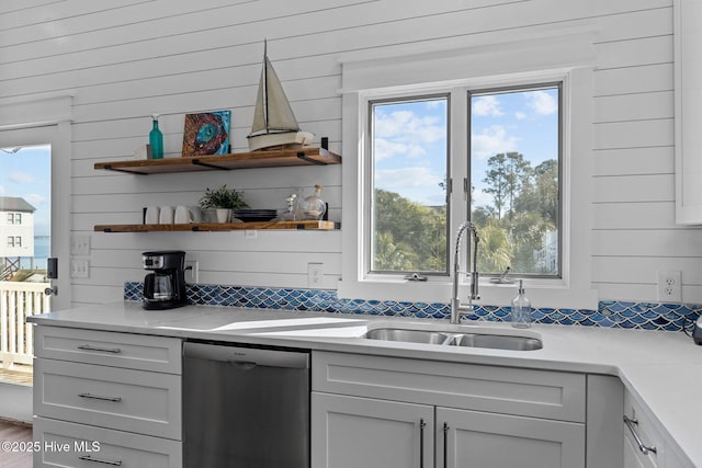 bar with dishwasher, tasteful backsplash, and a sink