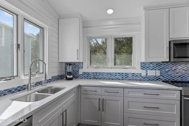 kitchen featuring a healthy amount of sunlight, tasteful backsplash, appliances with stainless steel finishes, and a sink