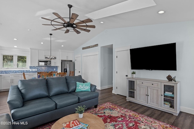 living room with baseboards, recessed lighting, ceiling fan, dark wood-type flooring, and lofted ceiling with skylight