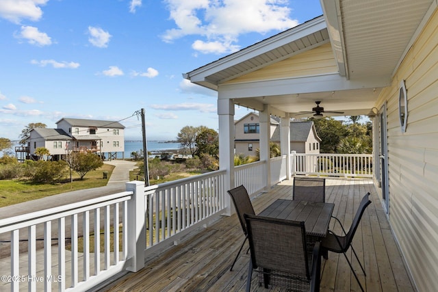 deck with a water view and a ceiling fan