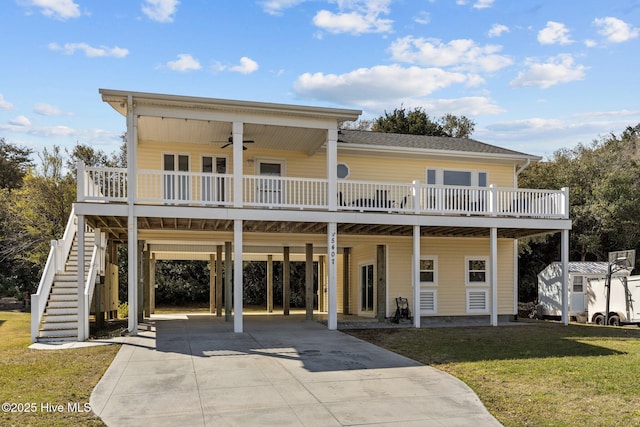 view of front of home featuring ceiling fan, stairway, concrete driveway, and a front lawn