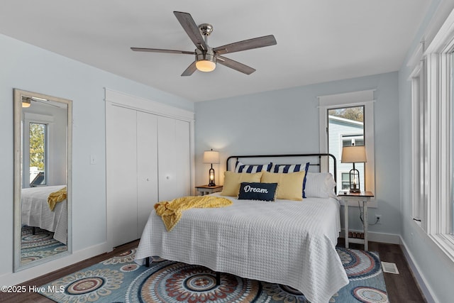 bedroom featuring visible vents, wood finished floors, a closet, baseboards, and ceiling fan