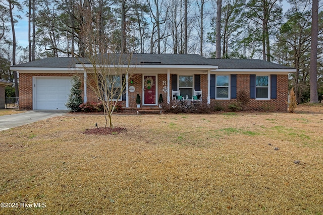 ranch-style house with driveway, brick siding, an attached garage, covered porch, and a front yard