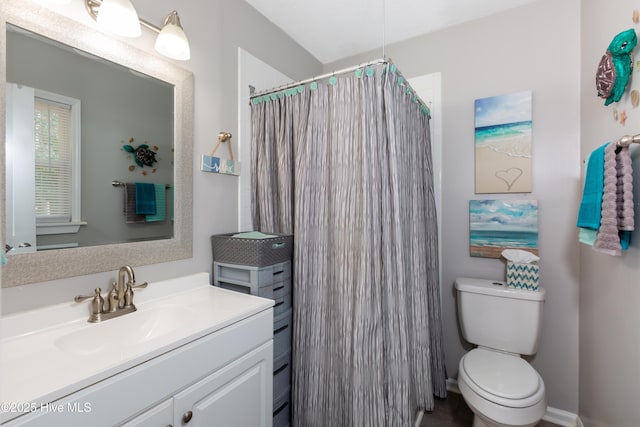 bathroom featuring a shower with shower curtain, vanity, and toilet