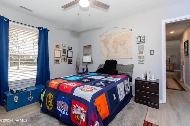 bedroom with visible vents, ceiling fan, and wood finished floors