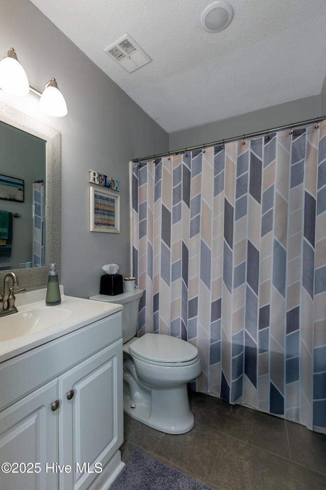 bathroom with visible vents, toilet, tile patterned flooring, a textured ceiling, and vanity