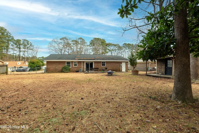 back of property with brick siding, fence, and a patio