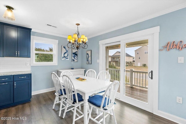 220 W Dolphin Dr, Oak Island, NC 28465 - dining room with dark wood-type flooring, a chandelier, baseboards, and crown molding