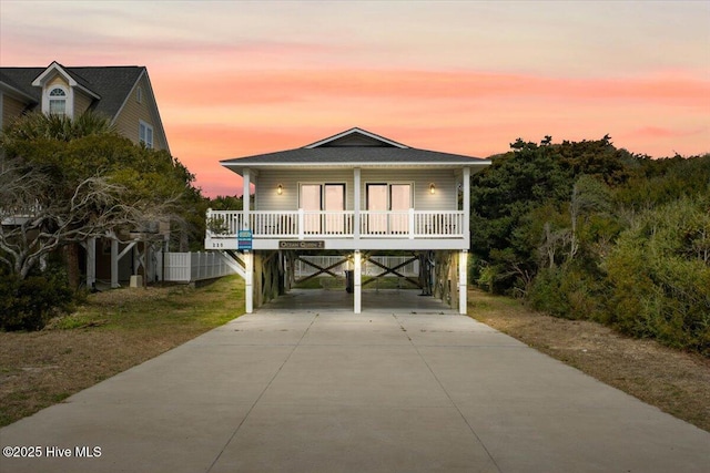 beach home featuring covered porch, a carport, and concrete driveway