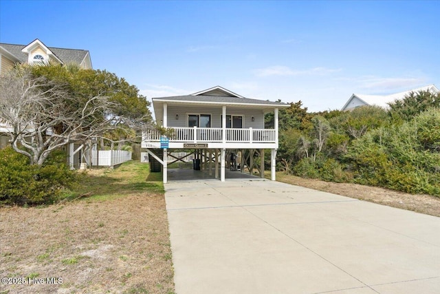 220 W Dolphin Dr, Oak Island, NC 28465 - coastal inspired home with a carport, driveway, and covered porch