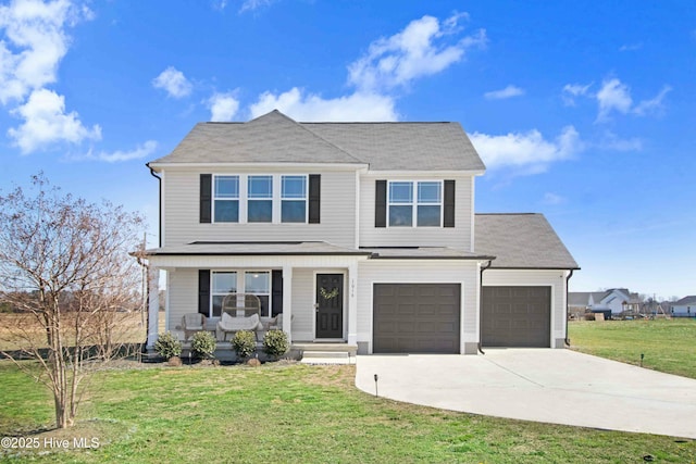 traditional-style house featuring a front yard, covered porch, and concrete driveway