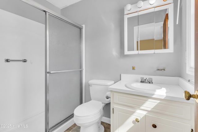 bathroom with toilet, a shower stall, and vanity