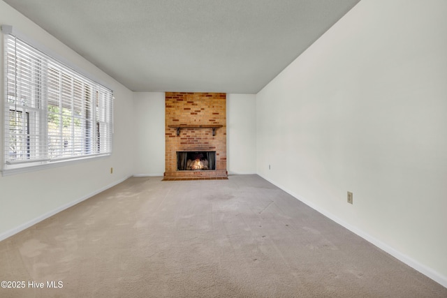 unfurnished living room with a brick fireplace, light carpet, and baseboards