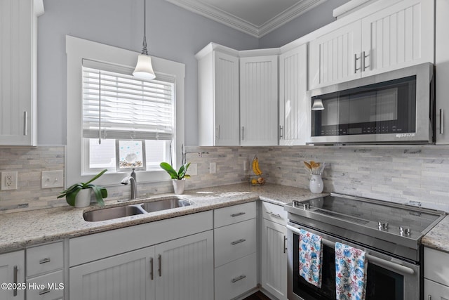 kitchen with a sink, white cabinetry, appliances with stainless steel finishes, crown molding, and decorative backsplash