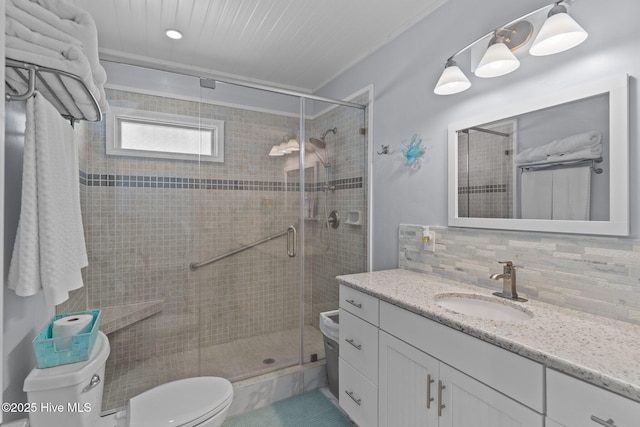 bathroom featuring tasteful backsplash, toilet, a stall shower, and vanity