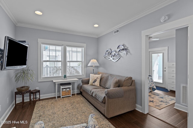 living room featuring dark wood-type flooring, crown molding, and visible vents