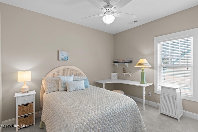 carpeted bedroom with visible vents, baseboards, and a ceiling fan