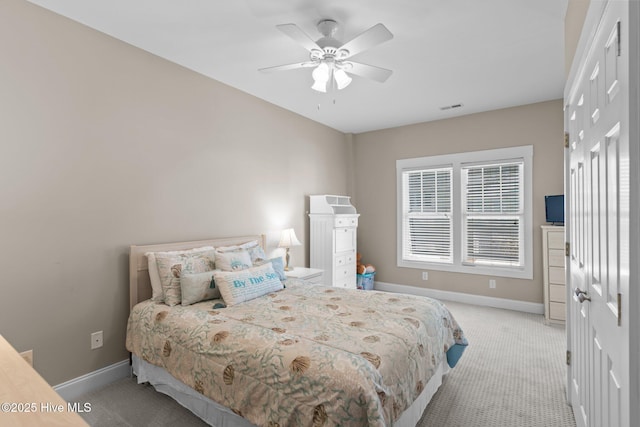 carpeted bedroom with visible vents, baseboards, and a ceiling fan