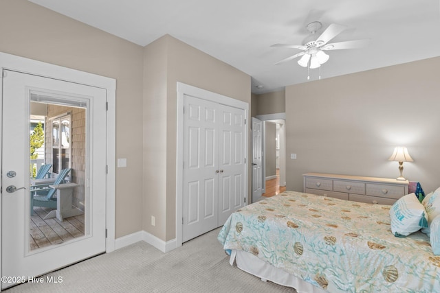 bedroom with a closet, light colored carpet, baseboards, and ceiling fan