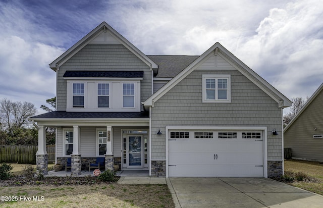 craftsman-style house featuring a garage, driveway, stone siding, fence, and a porch