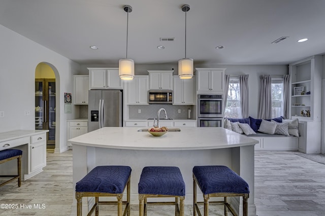 kitchen featuring appliances with stainless steel finishes, visible vents, a sink, and white cabinetry