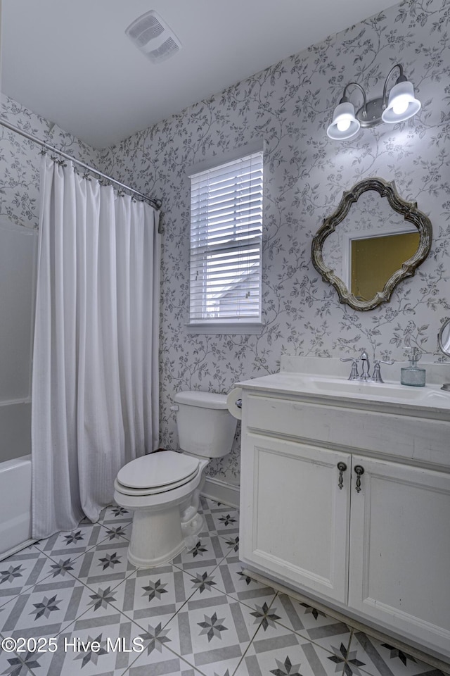 bathroom with toilet, visible vents, and wallpapered walls