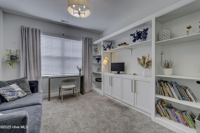 living area featuring light carpet, built in shelves, and visible vents