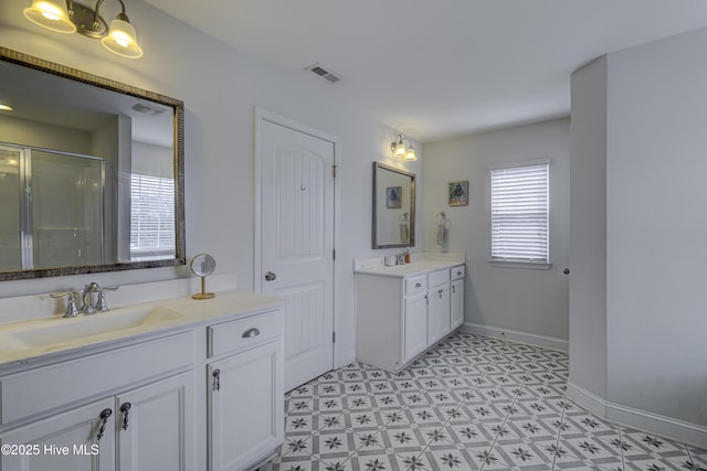 full bathroom with two vanities, a sink, baseboards, visible vents, and a shower stall